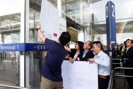 Officials post a court injunction to stop people from obstructing airport operations at an entrance to Terminal 1 of Hong Kong Airport