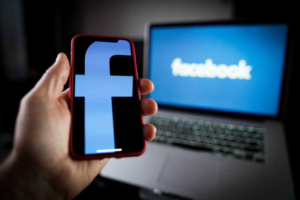 Il logo di Facebook su cellulare e su computer portatile (Photo by Jaap Arriens/NurPhoto/Getty Images)