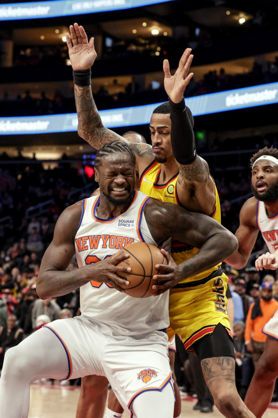 New York Knicks forward Julius Randle (30) tries to get position for a shot as Atlanta Hawks forward John Collins (20) defends during the second half of an NBA basketball game Saturday, Jan. 15, 2022, in Atlanta. (AP Photo/Butch Dill)