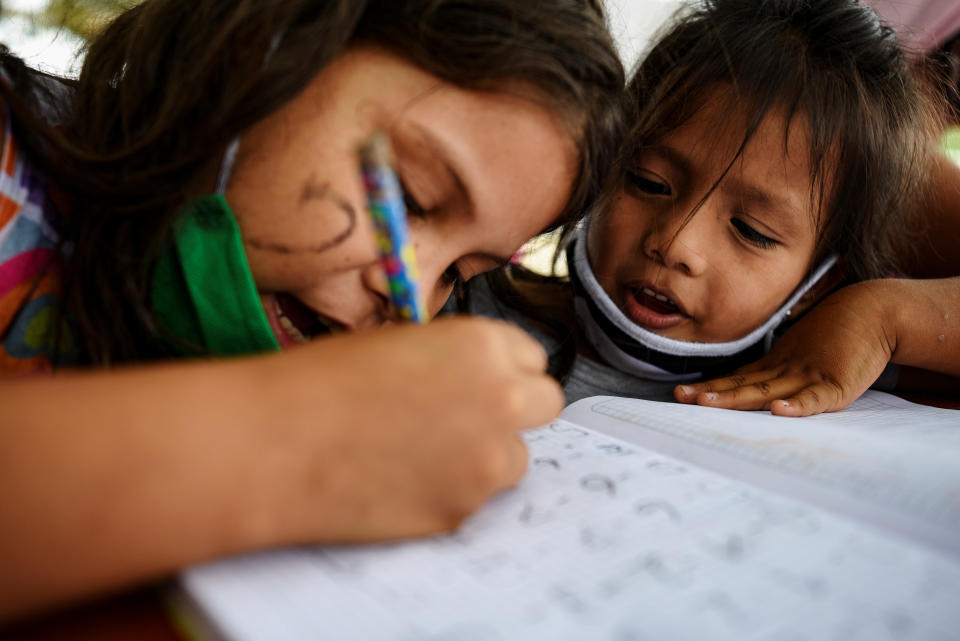 Keyla Vera y Ariana Rodríguez hacen ejercicios de matemáticas en este colegio improvisado del barrio Realidad de Dios de Guayaquil. (Foto: Santiago Arcos / Reuters).