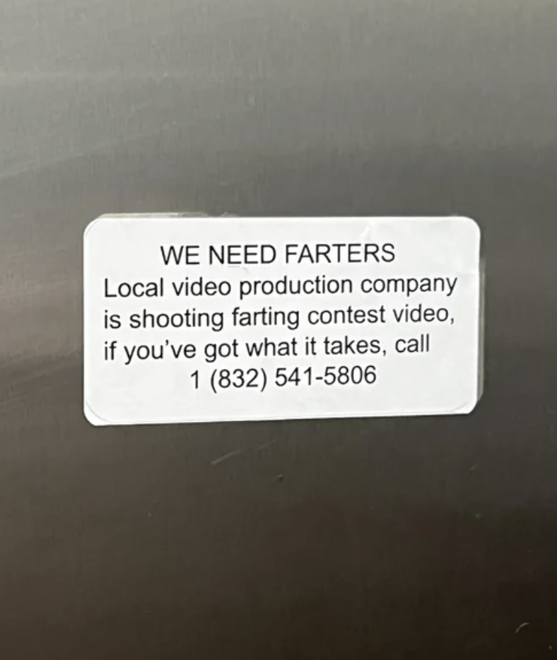 Sticker on a surface with text promoting a local farting contest and a phone number for contact