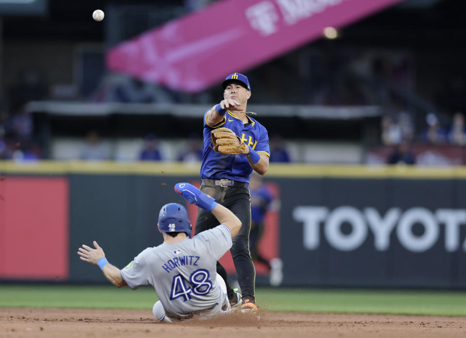 Toronto Blue Jays' Spencer Horwitz (48) is forced out at second as Seattle Mariners second baseman Dylan Moore, top, throws to first to complete a double play against Blue Jays' Bo Bichette during the sixth inning in a baseball game, Friday, July 5, 2024, in Seattle. (AP Photo/John Froschauer)