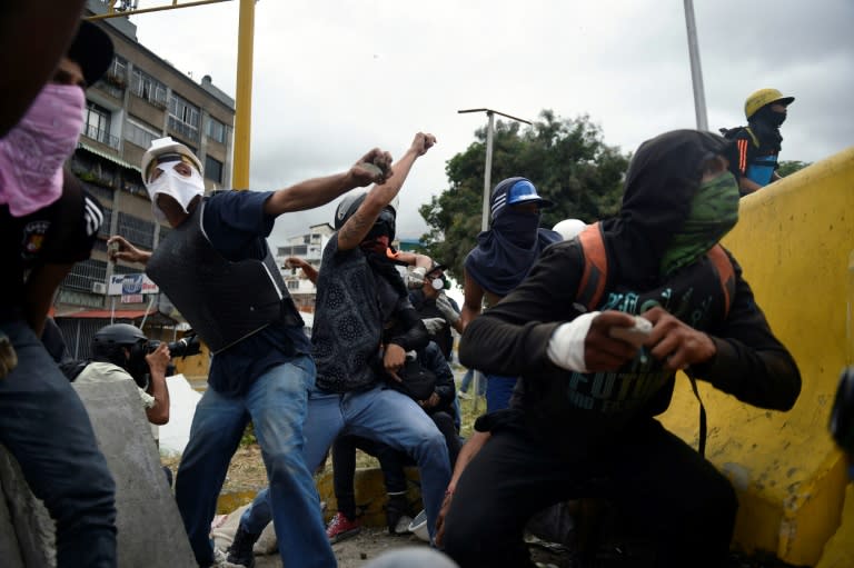 Demonstrators in Caracas hurl rocks at police during Venezuela's nationwide strike on Thursday