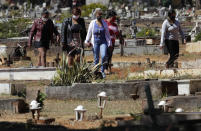 People arrive for the burial of Jose Mario de Souza Veiga, 83, whose family members said died of COVID-19, at the Campo da Esperanca cemetery on the border of the neighborhoods of Taguatinga and Ceilandia, in Brasilia, Brazil, Tuesday, July 21, 2020. (AP Photo/Eraldo Peres)