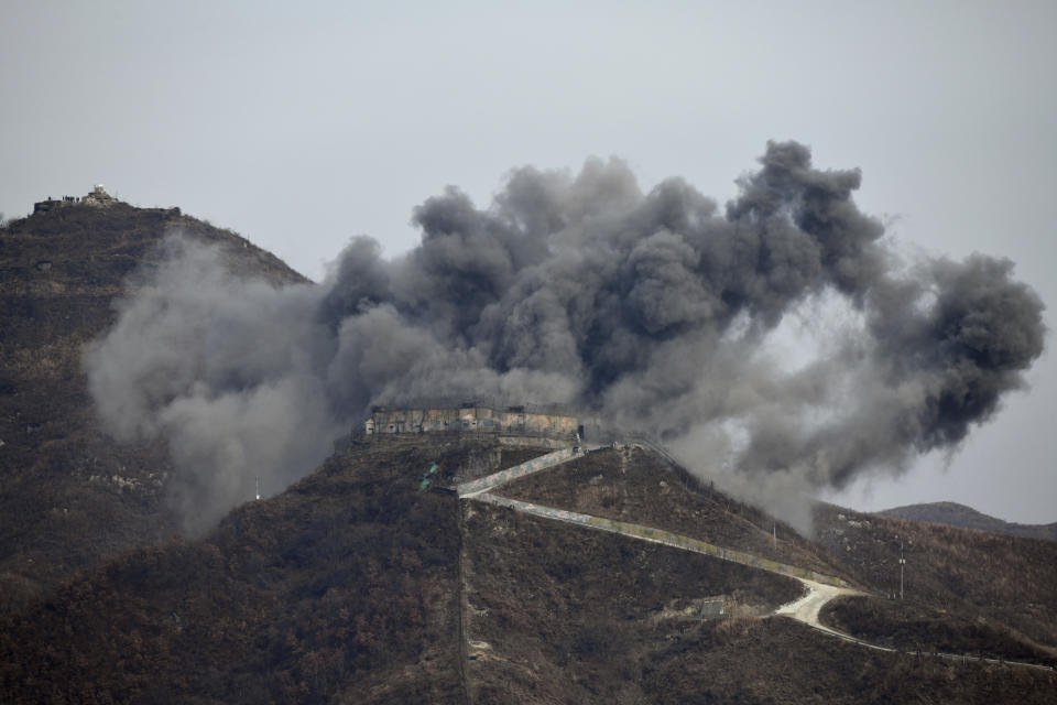 In this Thursday, Nov. 125, 2018, file photo, smoke from an explosion rises as part of the dismantling of a South Korean guard post in the Demilitarized Zone dividing the two Koreas in Cheorwon, as a North Korean guard post sits high in the upper left. (Jung Yeon-je/Pool Photo via AP, File)