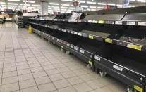 FILE - This Thursday, March 19, 2020 file photo shows empty shelves in a supermarket in London, amid panic-buying due to the coronavirus outbreak. A pandemic forcing everyone to stay home could be the perfect moment for online grocery services. In practice, they've been struggling to keep up with a surge in orders, highlighting their limited ability to respond to an unprecedented onslaught of demand. After panic buying left store shelves stripped of staples like pasta, canned goods and toilet paper, many shoppers quickly found online grocery delivery slots almost impossible to come by, too. (AP Photo/Kirsty Wigglesworth, File)