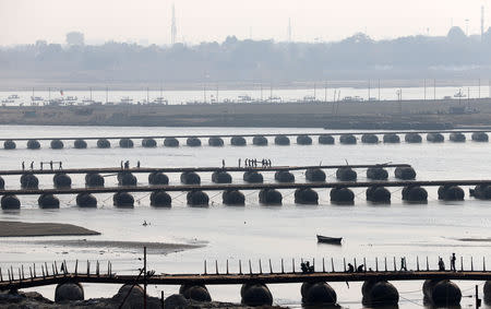 Labourers work on an under-construction pontoon bridge spanning the river Ganga ahead of the "Kumbh Mela", or the Pitcher Festival, in Allahabad, India, November 20, 2018. REUTERS/Jitendra Prakash