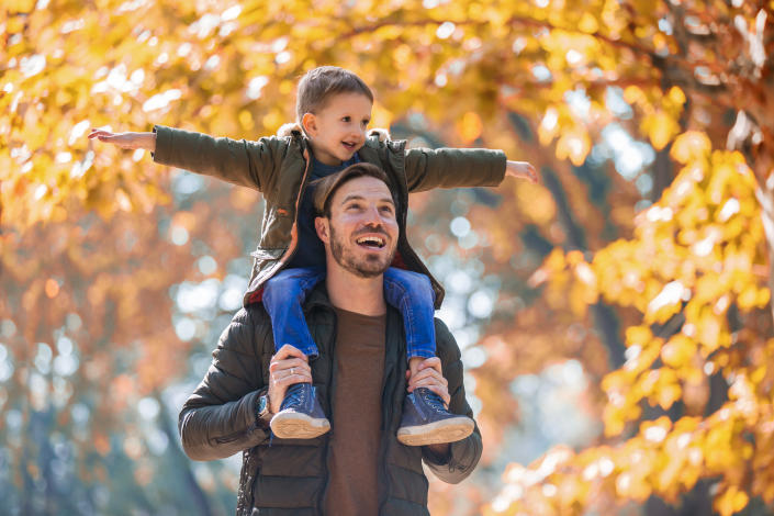 Father and son having fun in autumn park