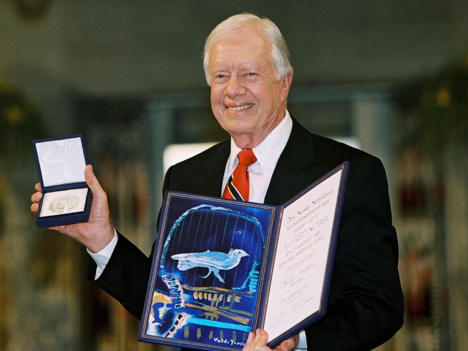 PHOTO: Former President Jimmy Carter holds up his Nobel Peace Prize in Oslo, Norway, Dec. 10, 2002. (Arne Knudsen/Getty Images)