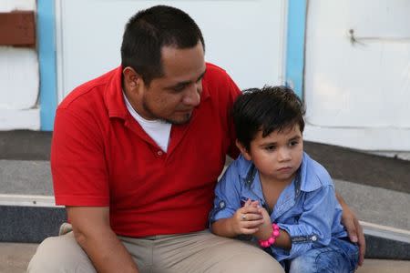 Walter Armando Jimenez Melendez, an asylum seeker from El Salvador, arrives with his four year-old son Jeremy at La Posada Providencia shelter in San Benito, Texas, U.S., shortly after he said they were reunited following separation since late May while in detention July 10, 2018. REUTERS/Loren Elliott