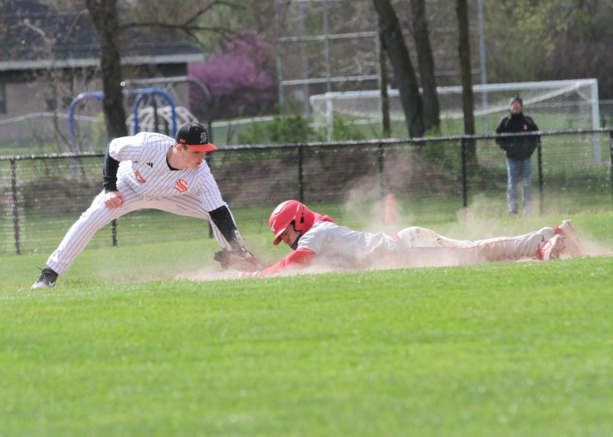 Constantine's Dathan Smith slides safely into third base before the tag from Gavin Lewis of Sturgis on Saturday.