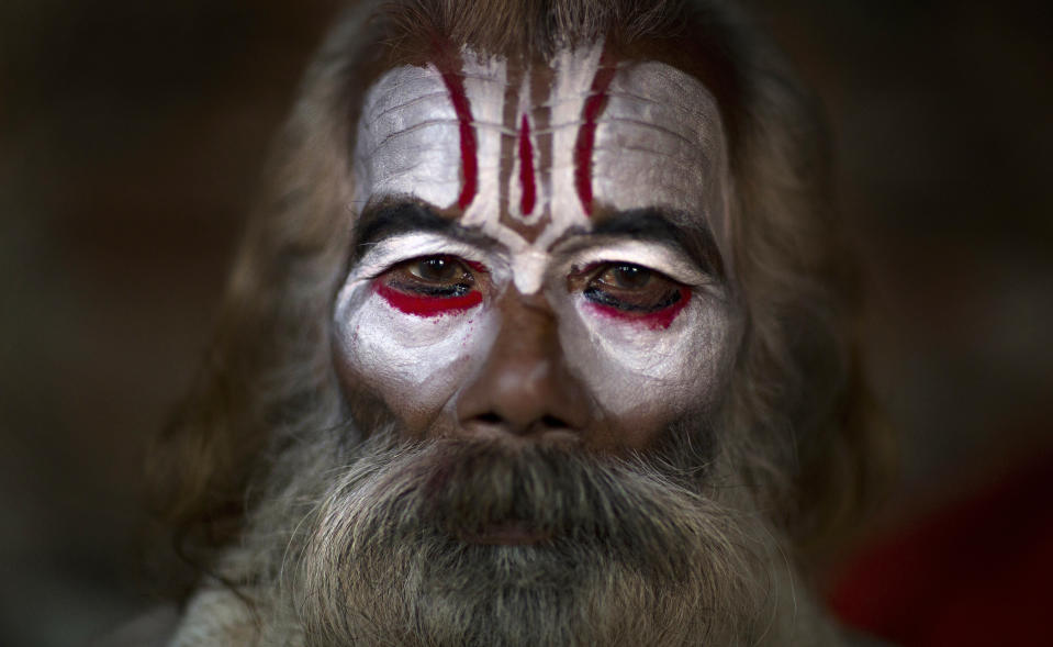 A Hindu holy man poses for a photograph as he smears his face with ash and vermilion powder at the courtyard of the Pashupatinath Temple during Shivaratri festival in Kathmandu, Nepal, Monday, March 4, 2019. Shivaratri, or the night of Shiva, is dedicated to the worship of Lord Shiva, the Hindu god of death and destruction. (Photo: Niranjan Shrestha/AP)