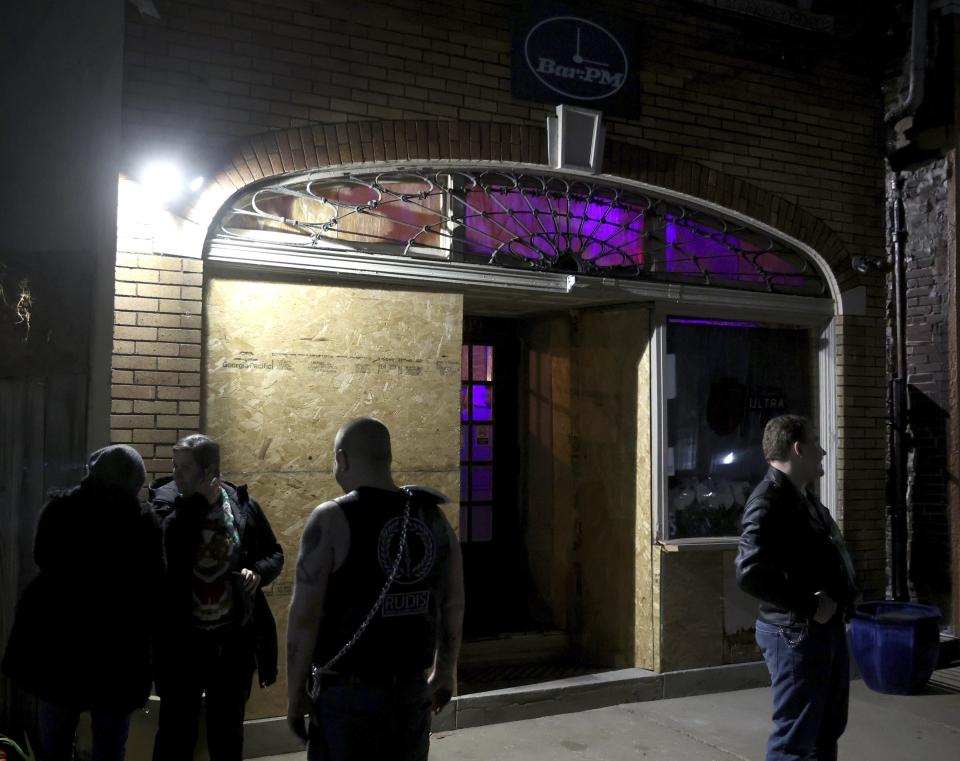 Windows are boarded up Tuesday, Dec. 19, 2023, at Bar:PM in the Carondelet neighborhood in St. Louis. Friends and supporters gathered at the bar after a police officer drove into the bar early Monday morning. Co-owner Chad Morris was arrested following the incident. (Christine Tannous/St. Louis Post-Dispatch via AP)