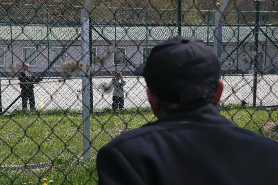 Hajdar Selimovic calls to his nephew Ismail behind a fence at a detention center where authorities have brought back from Syria 110 Kosovar citizens, mostly women and children in the village of Vranidol on Sunday, April 20, 2019. Four suspected fighters have been arrested, but other returnees will be cared for, before being sent to homes over the coming days, according to Justice Minister Abelard Tahiri.(AP Photo/Visar Kryeziu)