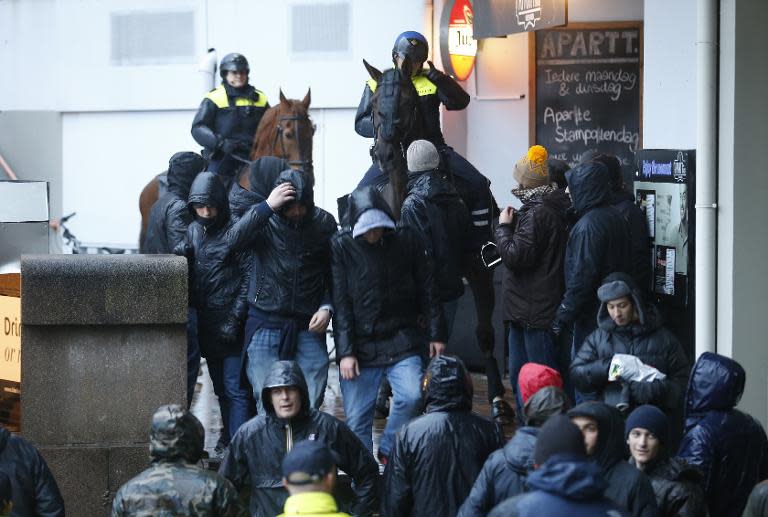 AS Roma fans who try to leave the old harbour in Rotterdam are contained by policemen on horseback prior to the Europa League game against Feyenoord on February 26, 2015