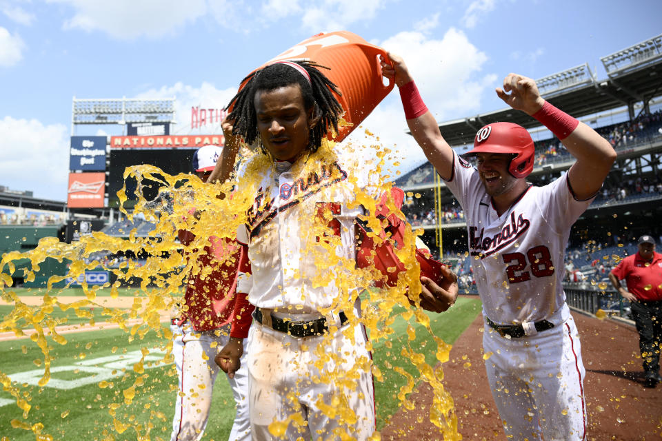 Washington Nationals' CJ Abrams, center, is doused by teammate Lane Thomas (28) after a baseball game against the Colorado Rockies, Wednesday, July 26, 2023, in Washington. Abrams drove in the game-winning run. The Nationals won 5-4. (AP Photo/Nick Wass)