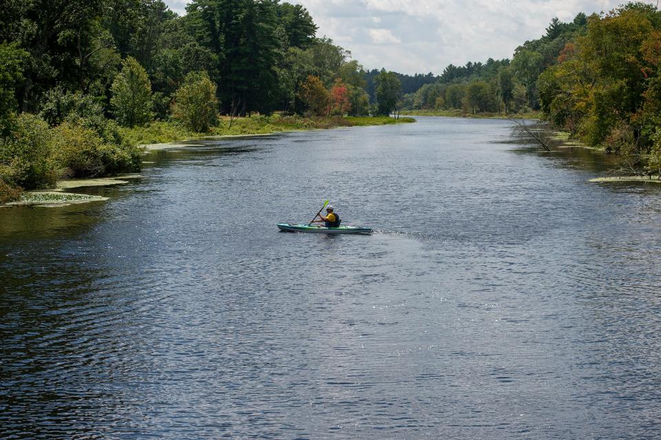 A kayaker paddles on the Charles River near the Farm Road Bridge in Dover, Aug. 11, 2023.