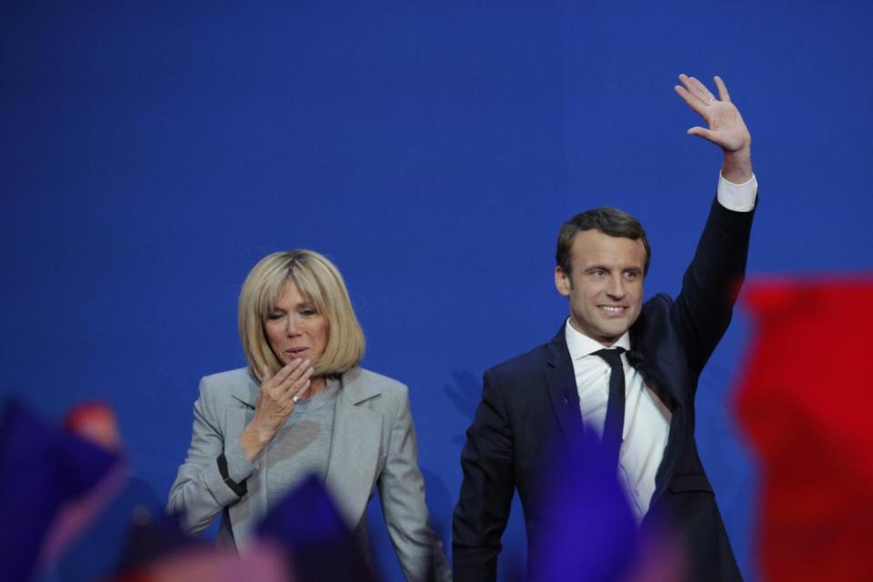 Emmanuel Macron waves as his wife Brigitte gestures before he addresses his supporters on election day (AP)