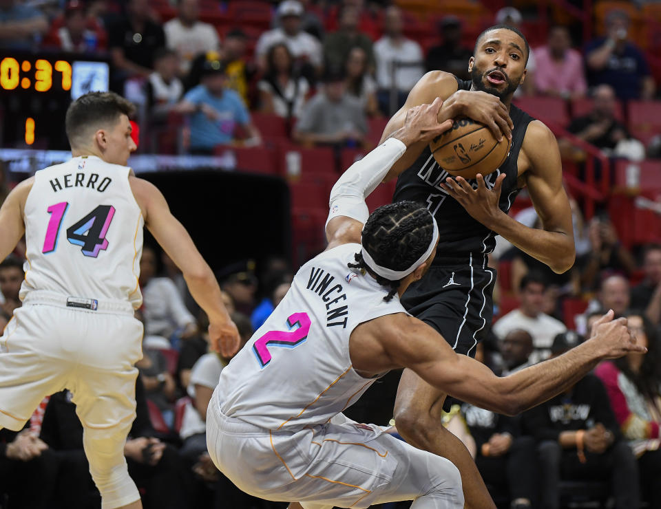 Brooklyn Nets forward Mikal Bridges (1) is fouled by Miami Heat guard Gabe Vincent (2) during the first half of an NBA basketball game, Saturday, March 25, 2023, in Miami, Fla. (AP Photo/Michael Laughlin)