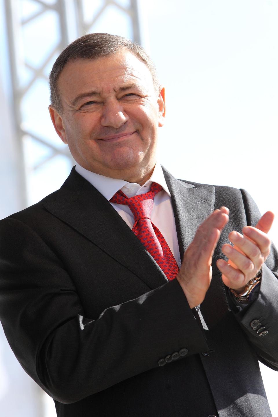 In this photo taken on Sunday, Sept. 15, 2013, Russian businessman and billionaire Arkady Rotenberg applauds during a local soccer match in St.Petersburg, Russia, Sunday, March 15, 2013. President Barack Obama on Thursday expanded U.S. economic sanctions against Moscow over its actions in Ukraine, targeting President Vladimir Putin's chief of staff and 19 other individuals as well as a Russian bank that provides them support. Those named in the sanctions Thursday include Arkady Rotenberg lifelong Putin friend whose company has amassed billions of dollars in government contracts. (AP Photo/Interpress, Alexander Kulebyakin)