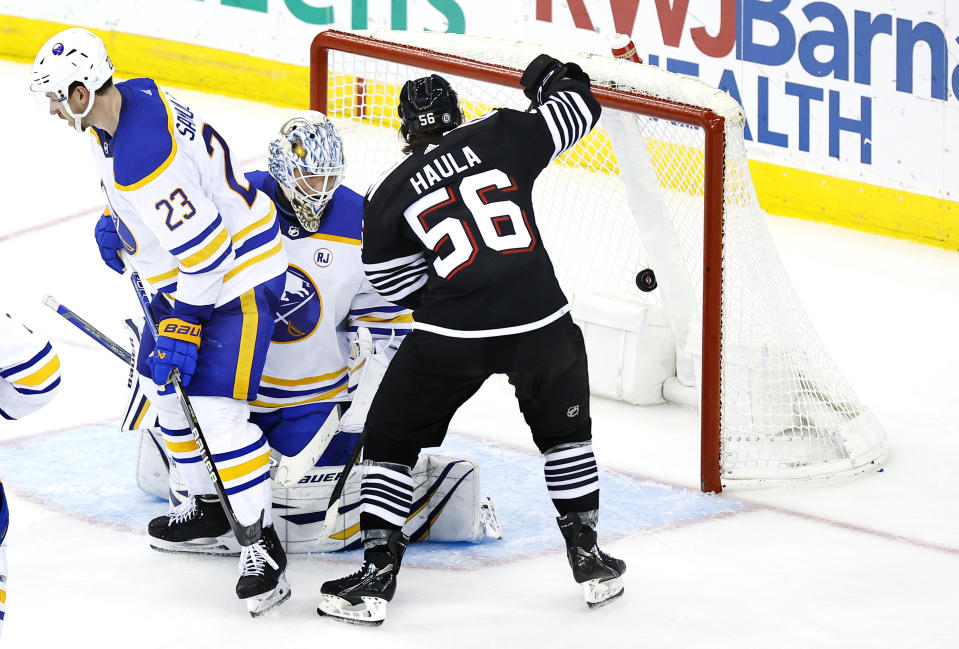 New Jersey Devils left wing Erik Haula (56) scores a goal against Buffalo Sabres defenseman Mattias Samuelsson (23) and goaltender Ukko-Pekka Luukkonen (1) during the third period of an NHL hockey game, Friday, Oct. 27, 2023, in Newark, N.J. (AP Photo/Noah K. Murray)