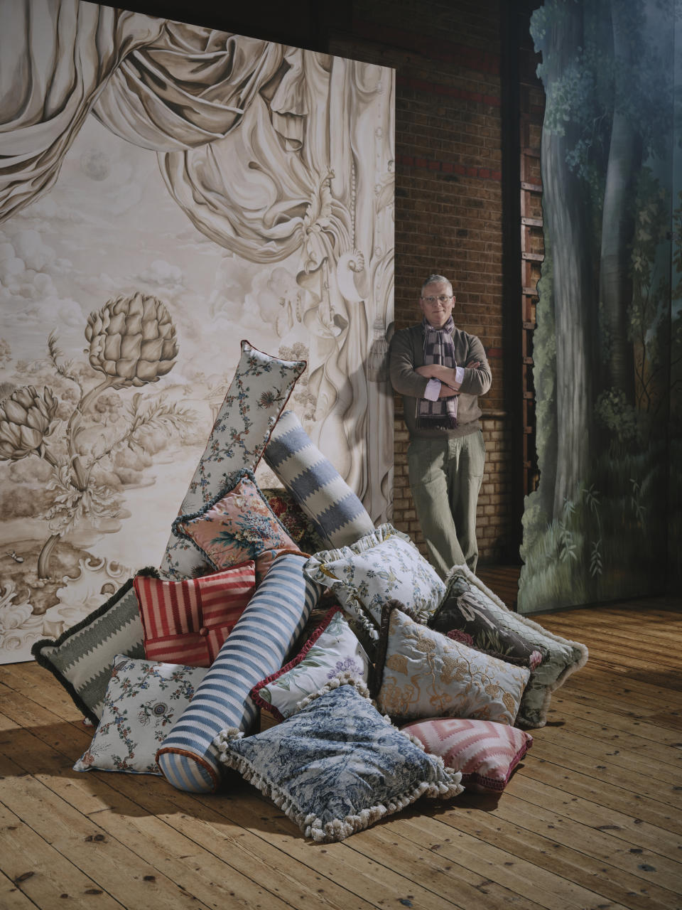 Giles Deacon posing with his wallpaper mural and fabric designs for Sanderson.