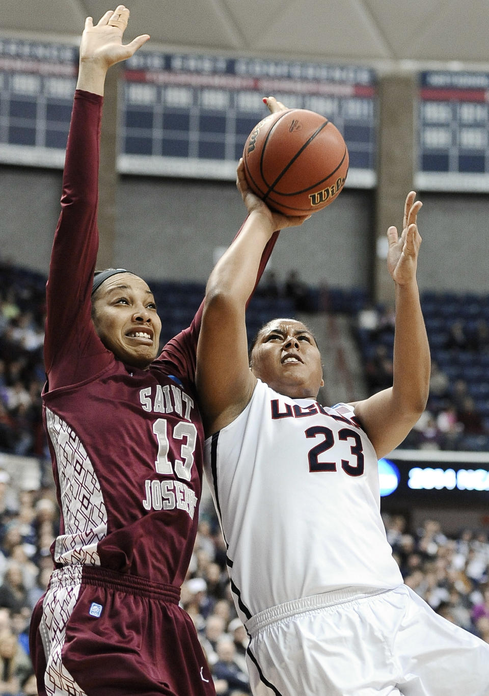 Saint Joseph's Ashley Robinson, left, fouls Connecticut's Kaleena Mosqueda-Lewis, right, as she makes a basket during the first half of a second-round game of the NCAA women's college basketball tournament, Tuesday, March 25, 2014, in Storrs, Conn. (AP Photo/Jessica Hill)