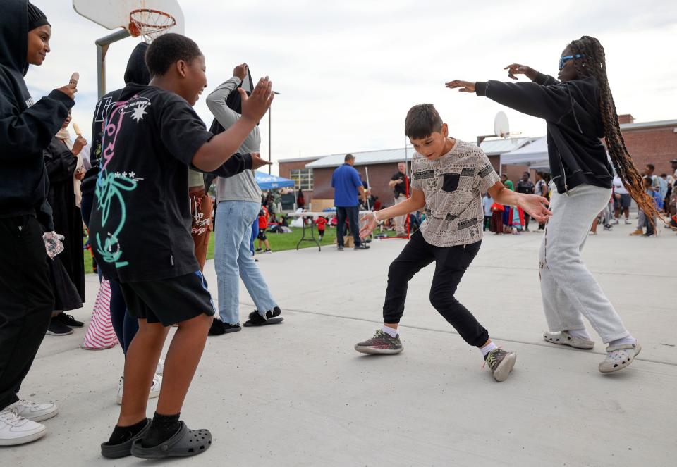 Abdul Bakhshi and Suki Lual, right, dance during Refugee Back to School Night at Granite Park Junior High in South Salt Lake on Monday, Aug. 7, 2023. | Kristin Murphy, Deseret News