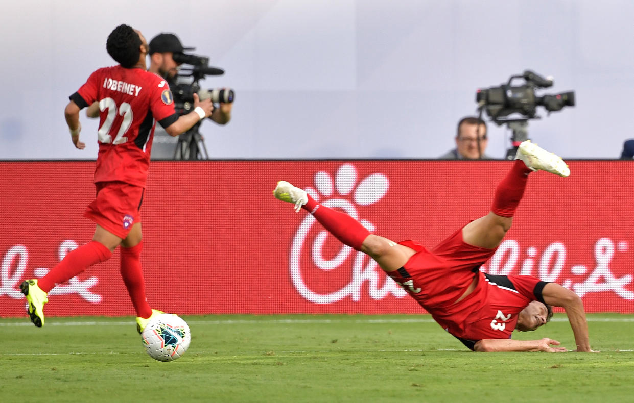 CHARLOTTE, NORTH CAROLINA - JUNE 23: Luis Paradela #23 of Cuba flips as he dives to intercept a pass against Canada during the second half of their Group A 2019 CONCACAF Gold Cup match at Bank of America Stadium on June 23, 2019 in Charlotte, North Carolina. Canada won 7-0. (Photo by Grant Halverson/Getty Images)