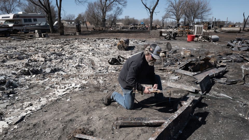 A homeowner cuts up the frame of his doublewide mobile after it was destroyed by the Smokehouse Creek Fire in Stinnett, Texas. - Scott Olson/Getty Images