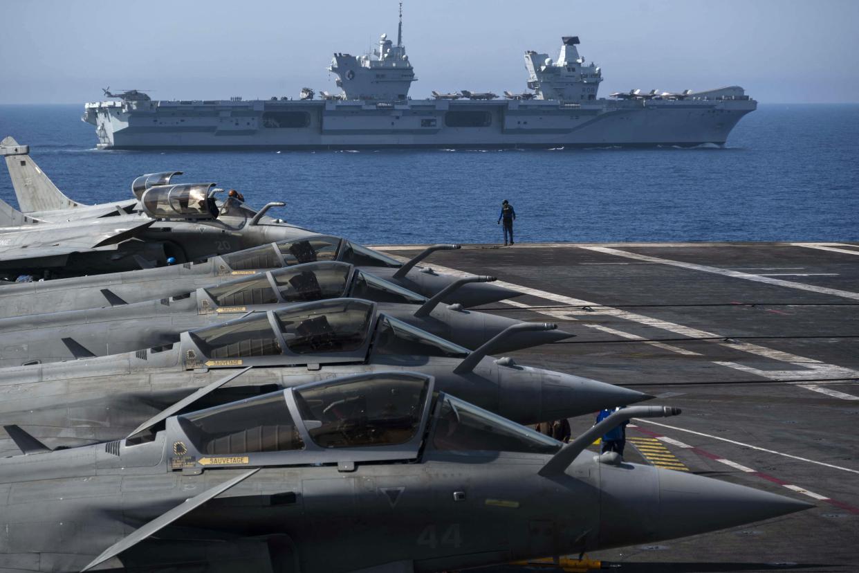 File: The French aircraft carrier Charles de Gaulle is seen with the UK Royal Navy's aircraft carrier HMS Queen Elizabeth in the background, during the exercise ‘Gallic strike’ off the coast of Toulon on 3 June 2021 (AFP via Getty Images)