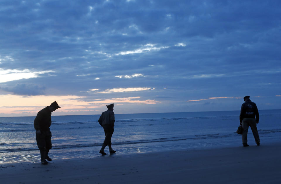 World War II reenactors walk along Omaha Beach, in Normandy, France, at dawn on Thursday, June 6, 2019 during commemorations of the 75th anniversary of D-Day. (AP Photo/Thibault Camus)