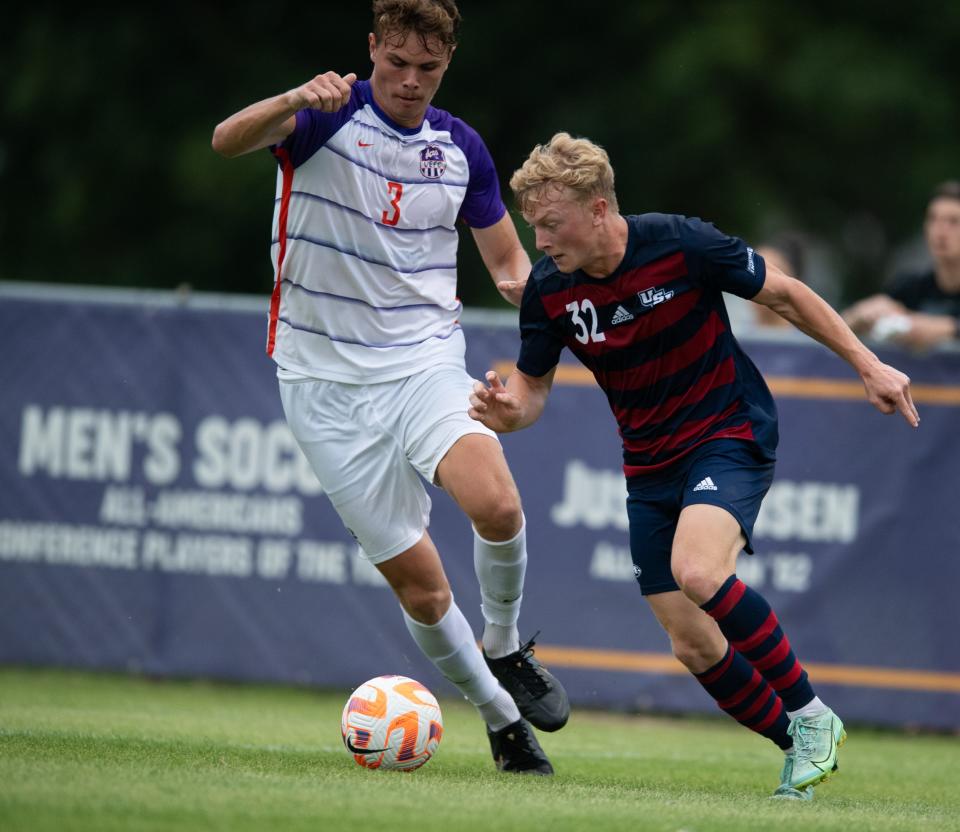 USI’s Jackson Mitchell (32) is defended by UE’s Ethan Garvey (3) as the USI Screaming Eagles play the UE Purple Aces at Arad McCutchan Stadium in Evansville, Ind., Saturday evening, Sept. 10, 2022. 