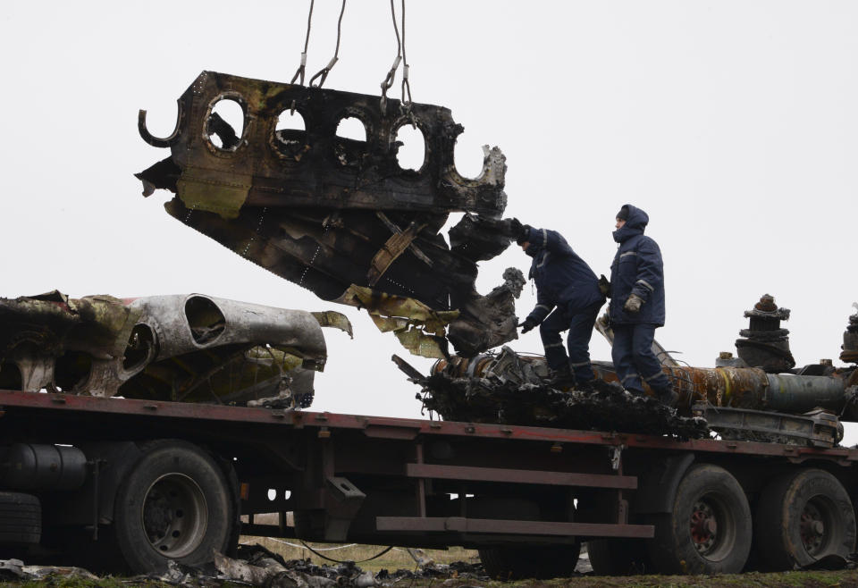 FILE - In this file photo dated Sunday, Nov. 16, 2014, recovery workers in rebel-controlled eastern Ukraine load debris from the crash site of Malaysia Airlines Flight 17, in Hrabove, Ukraine, with recovery operations carried out under the supervision of Dutch investigators and officials from the Organization for Security and Cooperation in Europe. Five years after a missile blew Malaysia Airlines Flight 17 out of the sky above eastern Ukraine, relatives and friends of those killed will gather Wednesday July 17, 2019, at a Dutch memorial to mark the anniversary.(AP Photo/Mstyslav Chernov, FILE)