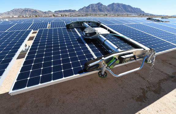 A panel-washing robot cleans a row of solar panels at Nellis Air Force Base in Las Vegas, Feb. 16, 2016.