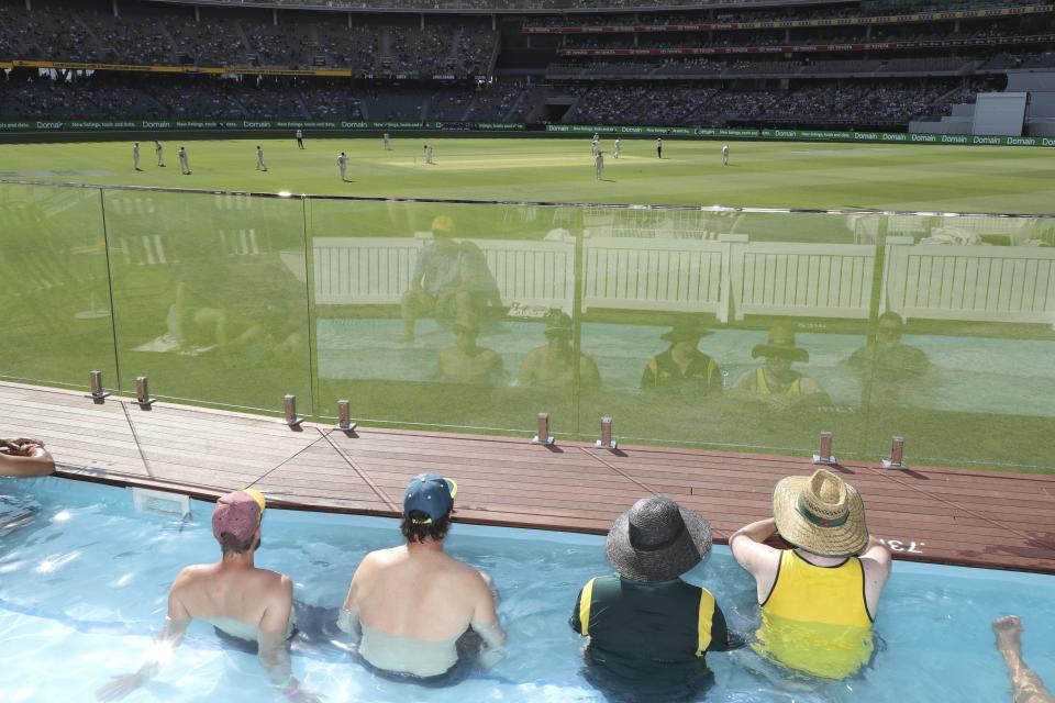 Cricket fans watch from a promotional pool area on the boundary, during play in the Australia versus New Zealand cricket test in Perth, Australia, Thursday, Dec. 12, 2019. Temperatures are forecasted to rise above 40C, (104F). (AP Photo/Trevor Collens)