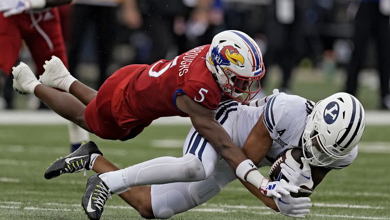BYU wide receiver Keanu Hill is tackled by Kansas safety O.J. Burroughs (5) during the first half of an NCAA college football game Saturday, Sept. 23, 2023, in Lawrence, Kan. 