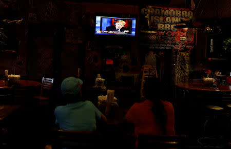 Local residents watch U.S. President Donald Trump speak on television regarding the North Korea crisis, at a restaurant, on the island of Guam, a U.S. Pacific Territory, August 14, 2017. REUTERS/Erik De Castro