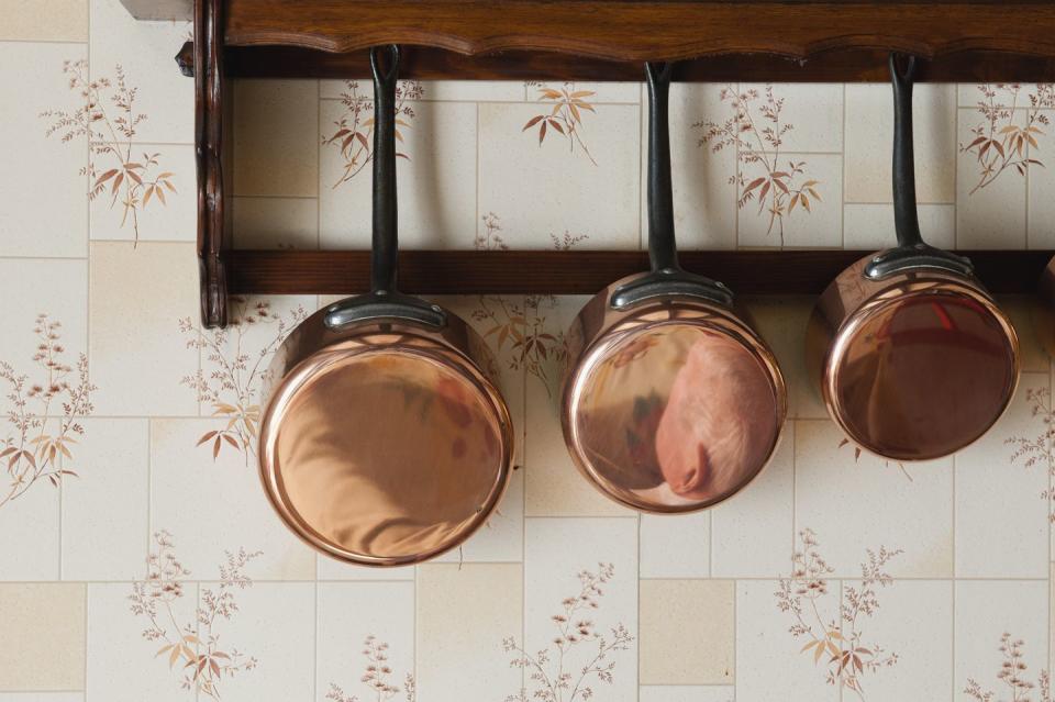 copper pots hanging on wall rack