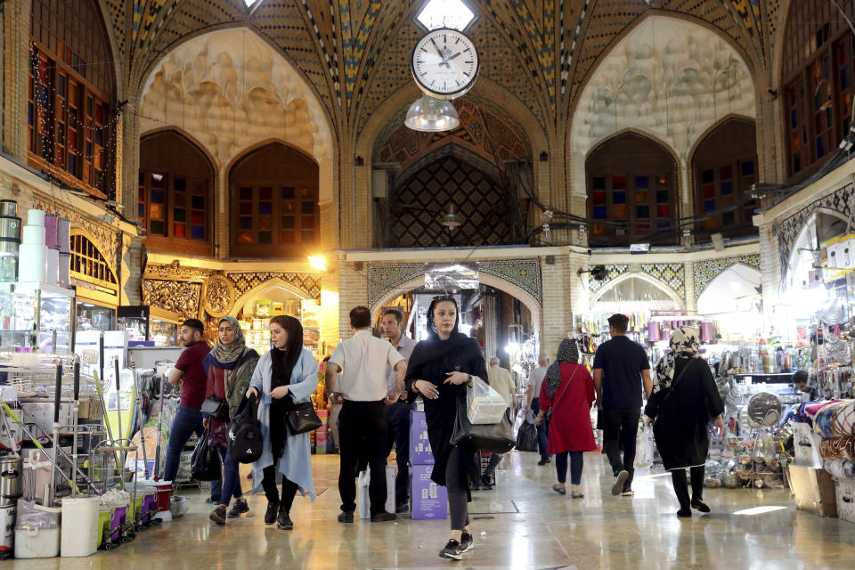 People shop at the old main bazaar in Tehran, Iran, Sunday, June 23, 2019. The most-visible place to see the effect of the economic hardship most face comes from walking by any money-exchange shop. Depreciation and inflation makes everything more expensive, from fruits and vegetables to tires and oil all the way to the big-ticket items, like mobile phones. (AP Photo/Ebrahim Noroozi)