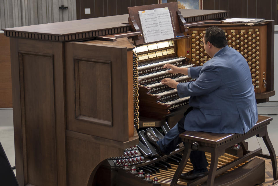 David La'O Ball, organist and head of music ministry at Christ Cathedral, plays the Hazel Wright organ at Christ Cathedral in Garden Grove, Calif., Tuesday, Feb. 15, 2022. The organ, named after its original benefactor, now has 17,000 pipes, 15 divisions and 293 ranks. The organ is the fifth-largest pipe organ in the world. (AP Photo/Damian Dovarganes)