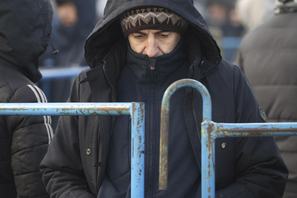 A migrant stands at the logistics center "Bruzgi" at the Belarus-Poland border near Grodno, Tuesday, Nov. 30, 2021. The West has accused Belarusian President Alexander Lukashenko of luring thousands of migrants to Belarus with the promise of help to get to Western Europe to use them as pawns to destabilize the 27-nation European Union in retaliation for its sanctions on his authoritarian government. Belarus denies engineering the crisis. (Oksana Manchuk/BelTA via AP)