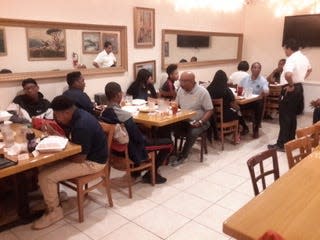 Stan Hixon and Nick Rhodes teach students dining etiquette as part of the 100 Black Men program. PHOTO COURTESY OF JERRY JACKSON