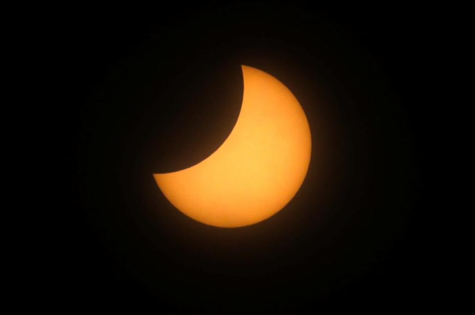 The sun creeps behind the moon during a total eclipse.