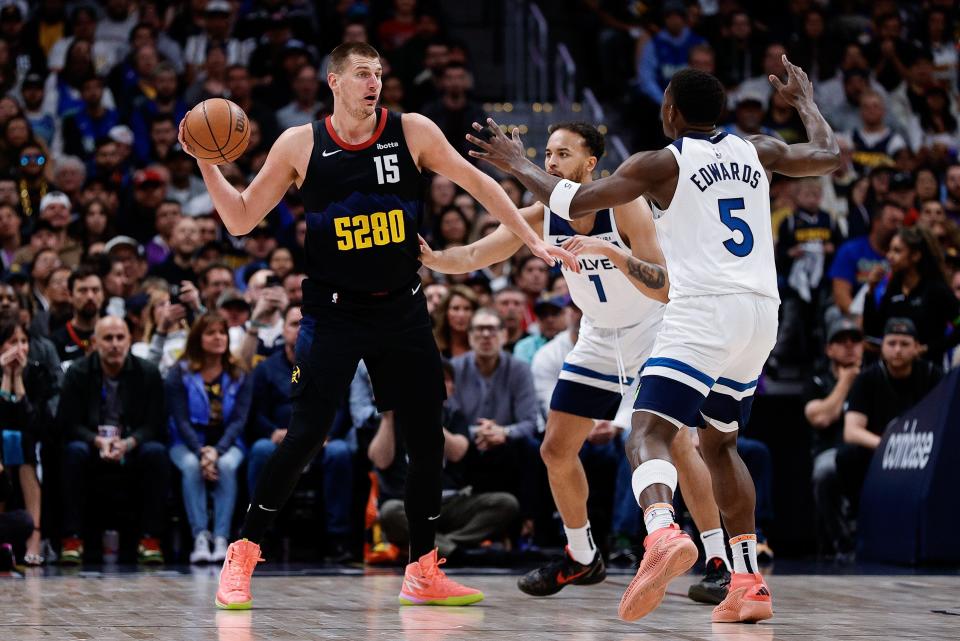 Denver Nuggets center Nikola Jokic (15) controls the ball as Minnesota Timberwolves forward Kyle Anderson (1) and guard Anthony Edwards (5) defend in the first quarter during game two of the second round for the 2024 NBA playoffs at Ball Arena.
