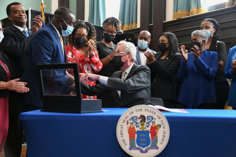 Governor Phil Murphy signs legislation establishing a Black Heritage Trail in New Jersey then hands his pen to Cape May County Assemblyman Antwan McClellan, who introduced the bill that lead to the law, on Wednesday, Sept. 7, 2022(OIT/NJ Governor’s Office).