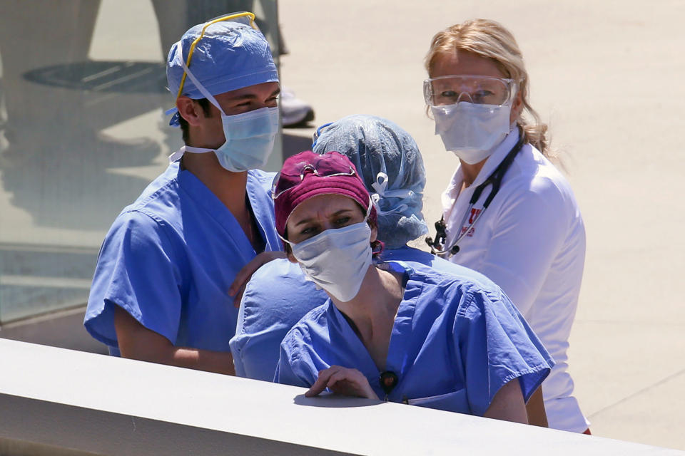 FILE - In this Thursday, April 30, 2020 file photo, Health care workers look on during a flyover at the University of Utah Hospital in Salt Lake City. One of Utah's largest hospitals had no beds left Friday, Oct. 16, 2020 in its regular intensive-care unit as the governor declared the state's weeks long spike in coronavirus cases "unsustainable." The University of Utah Health had to set up extra ICU beds staffed by doctors and nurses working overtime to care for its critical patients this week as the unit hit 104% capacity, said Chief Medical Officer Dr. Russell Vinik. (AP Photo/Rick Bowmer, File)