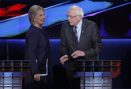 Democratic U.S. presidential candidates Hillary Clinton and Bernie Sanders talk during a commercial break at the Democratic U.S. presidential candidates' debate in Flint, Michigan, March 6, 2016. REUTERS/Jim Young