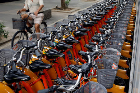 FILE PHOTO: A man rides a bicycle passing a station with bicycles of Youbike, a bicycle sharing system, in Taipei, Taiwan August 31, 2017. REUTERS/Tyrone Siu/File Photo