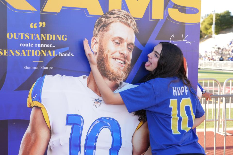 A Rams fan expresses her support for Cooper Kupp in front of an image of the receiver ahead of Super Bowl 56.